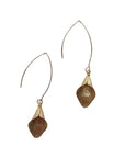 Close-up of sculptural lily-shaped brass earrings