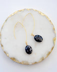 Close-up of black oval earrings with faceted glass