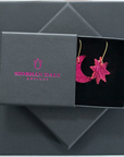 Metallic pink leather moon and star earrings with gold hooks, presented in a Siobhán Daly Designs branded gift box