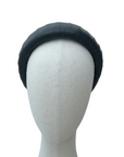 Black padded headband displayed on a neutral mannequin head against a white background