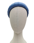 Sky blue padded satin headband displayed on a neutral-toned mannequin head against a white background