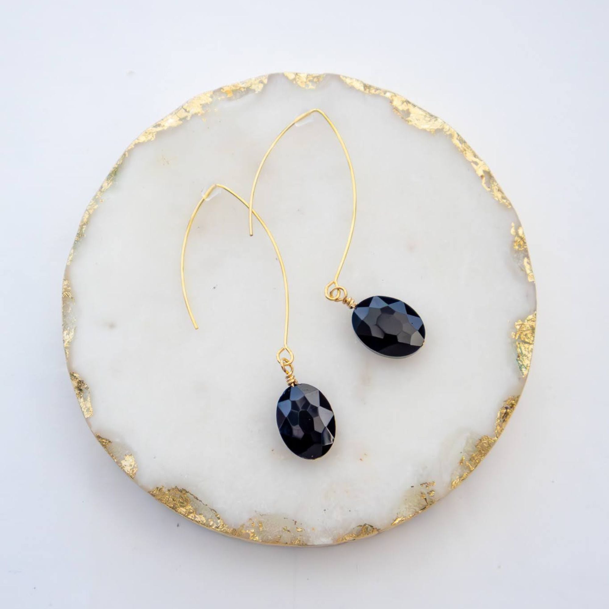 Close-up of black oval earrings with faceted glass