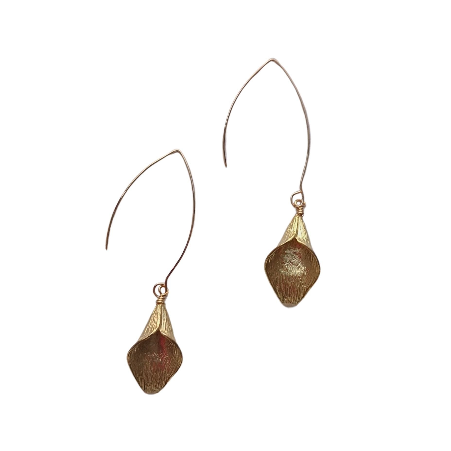 Close-up of sculptural lily-shaped brass earrings