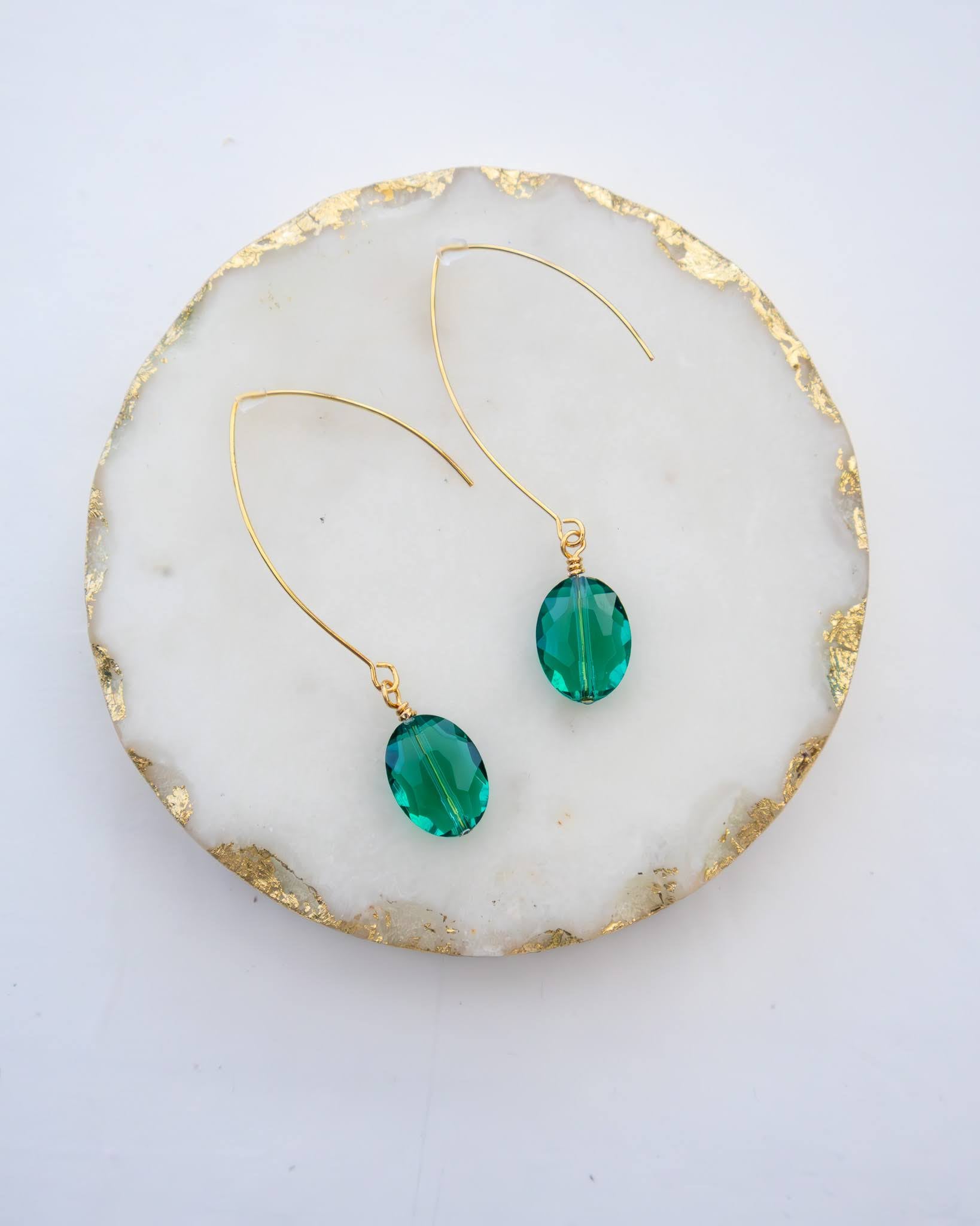 Close-up of green oval earrings with faceted glass