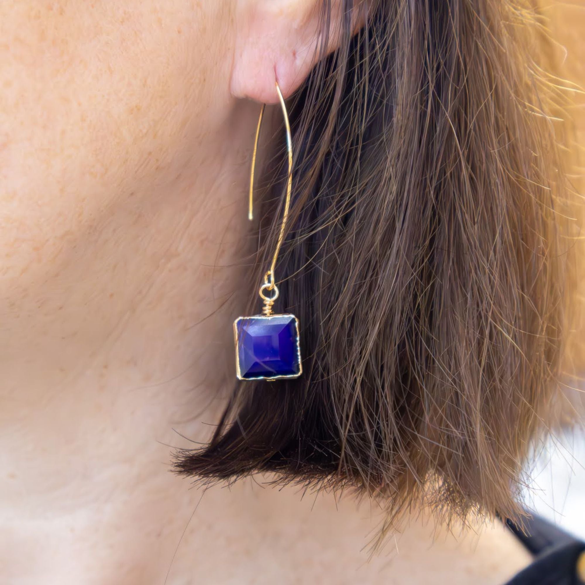 Blue statement earrings on model with fair skin