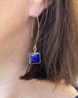Blue statement earrings on model with fair skin
