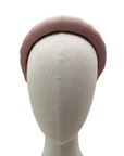 Dusky pink padded satin headband displayed on a neutral mannequin head against a white background