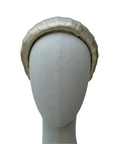 Textured champagne-gold headband with a soft sheen, shown on a fabric-covered mannequin head