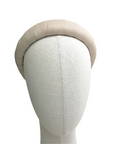Ivory satin-look padded headband displayed on a neutral mannequin head against a white background