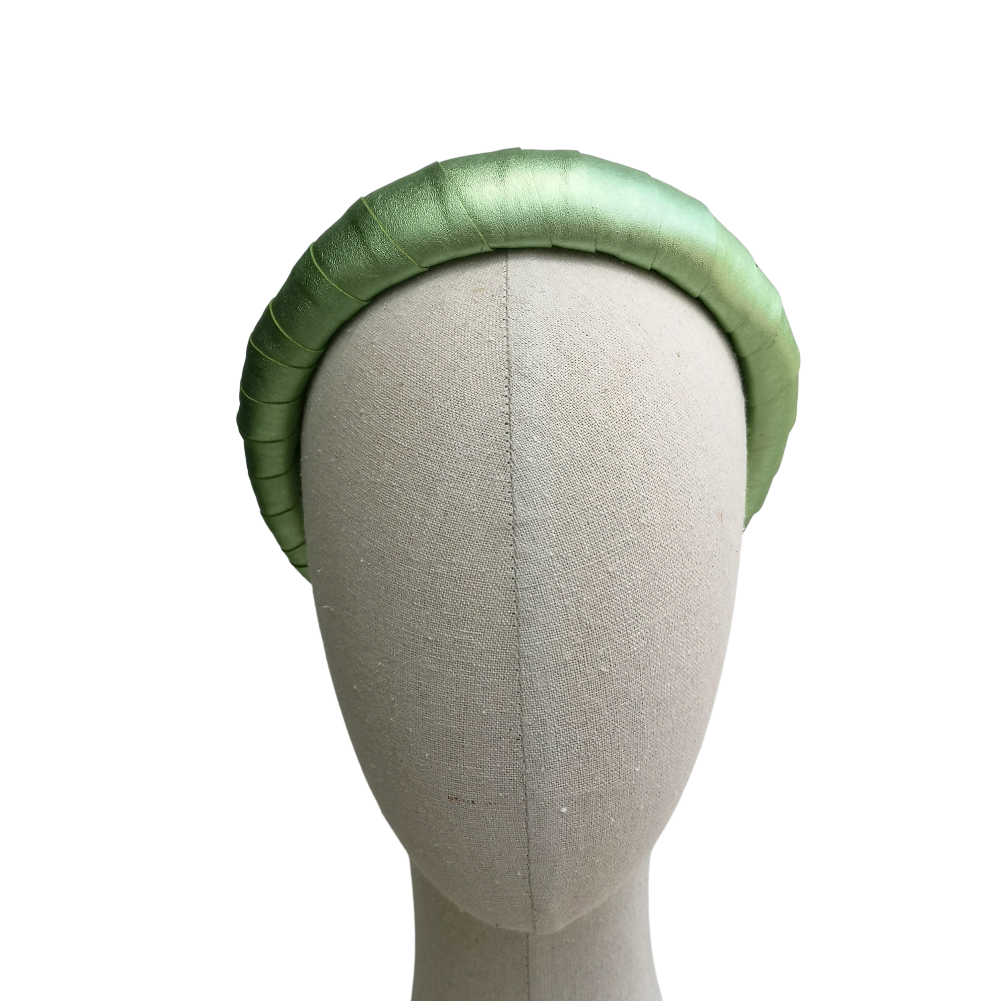 Metallic green satin-look padded headband on a neutral mannequin head with white background